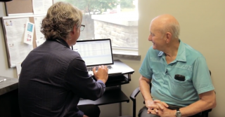 Dr. Kirk Hollohan with his patient viewing patient data on his computer